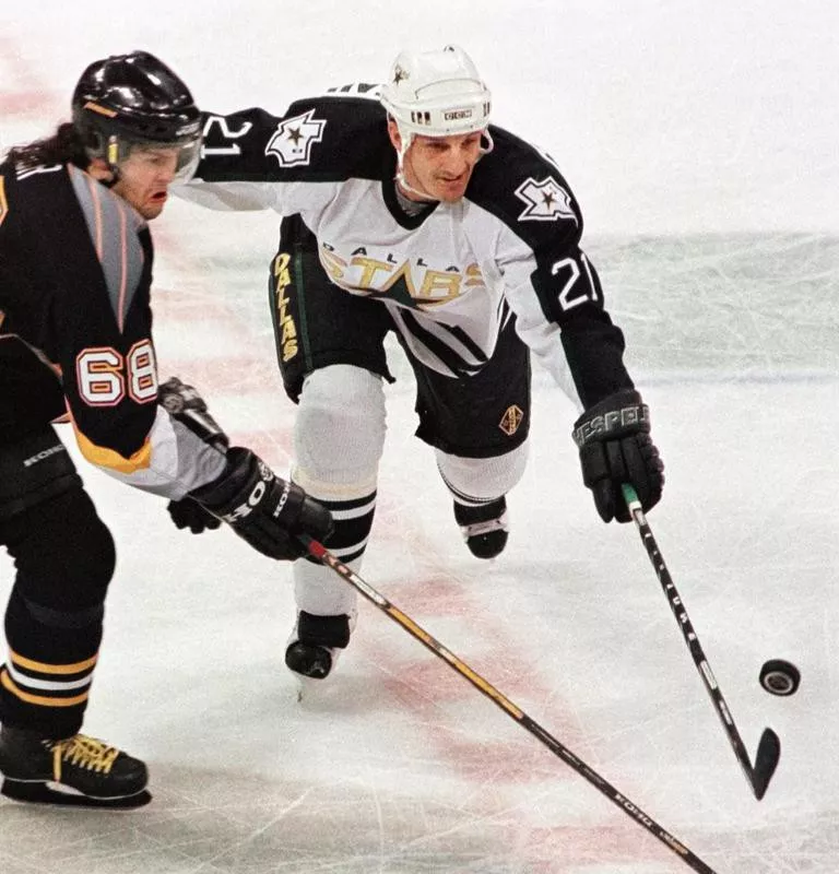 Guy Carbonneau knocks airborne puck away from Pittsburgh Penguins