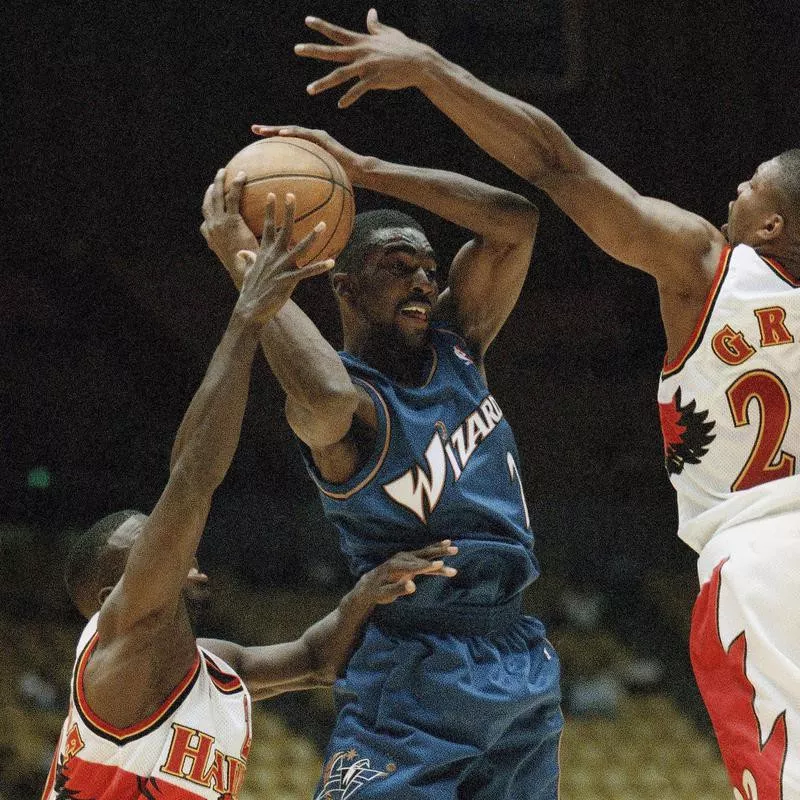 God Shammgod looks to pass between two Atlanta Hawks defenders Donald Whiteside and Ed Gray