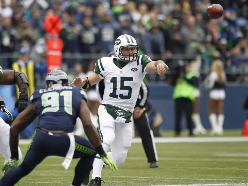 New York Jets' Tim Tebow passes under pressure