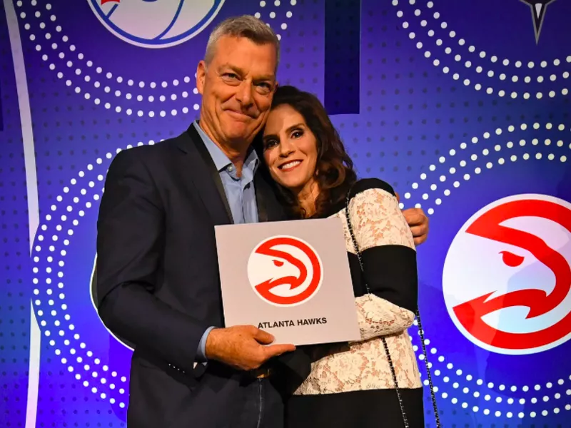 Jami Gertz holding Atlanta Hawks sign