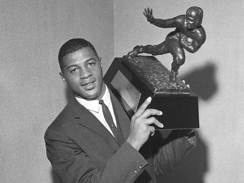 Ernie Davis holding the Heisman Trophy