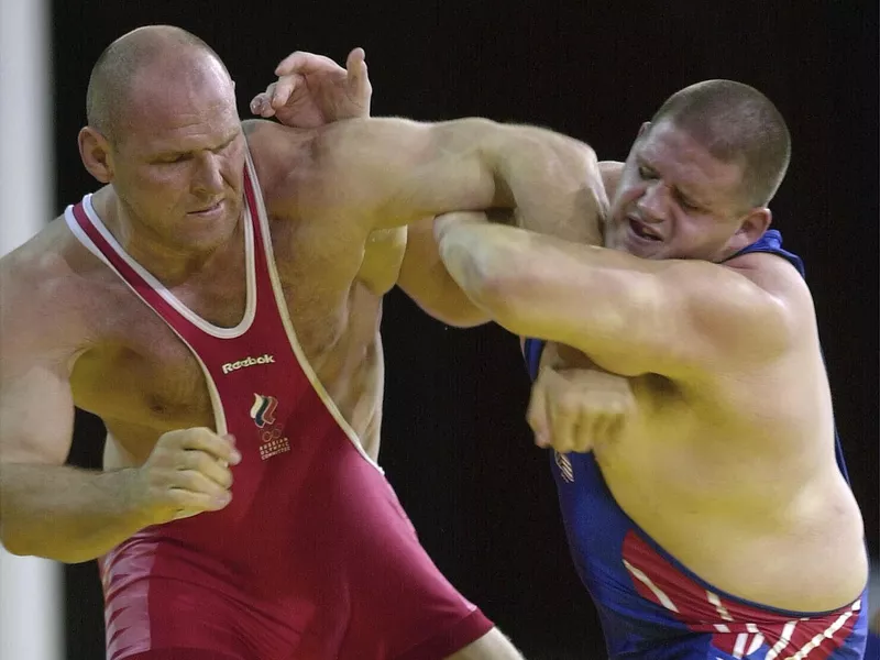 Rulon Gardner holds arm of Aleksandr Karelin