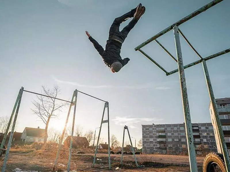 Man jumping off bars