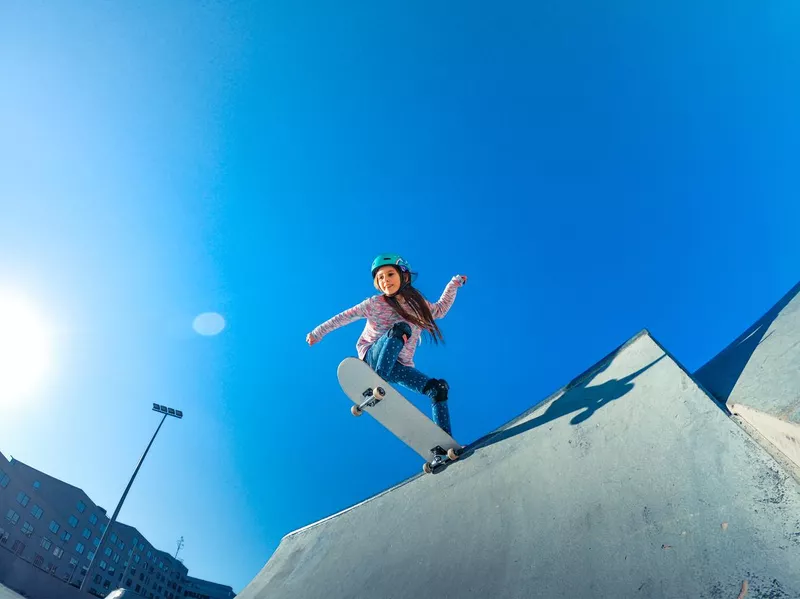 Little girl standing on the edge of the skate park ramp