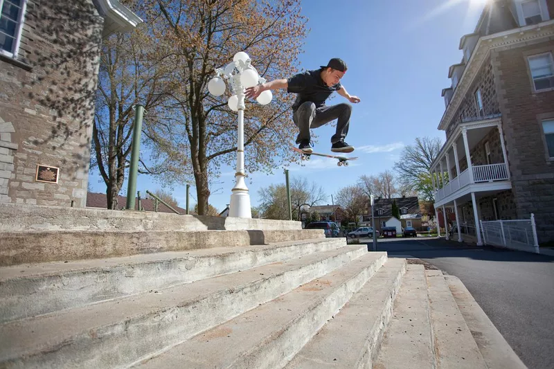 Skateboarder doing an ollie down to the stairs