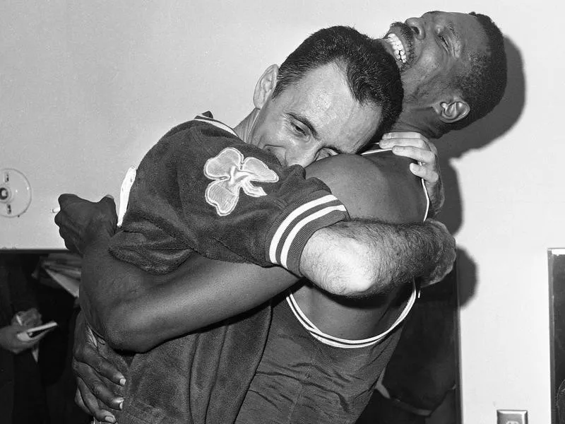 Bill Russell hoists teammate Bob Cousy in a victory hug