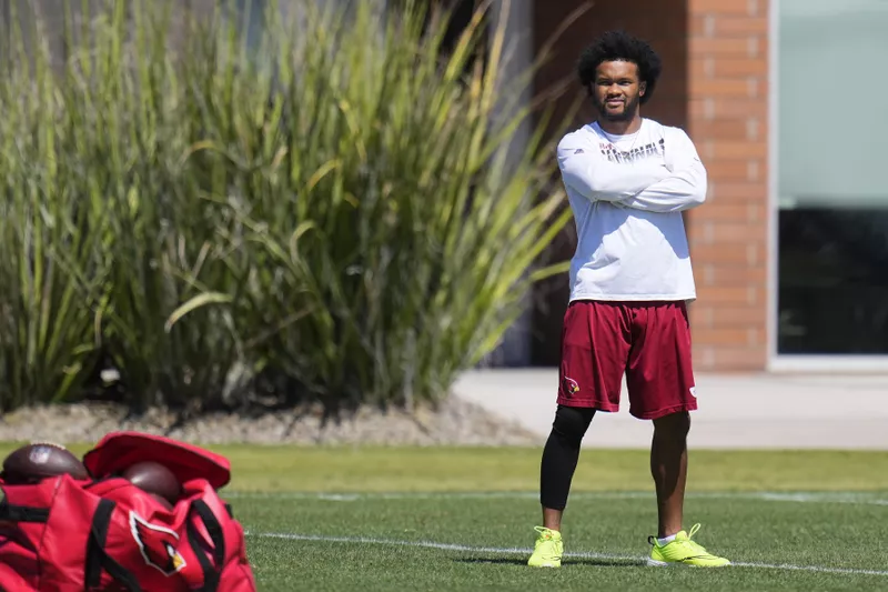 Injured Arizona Cardinals quarterback Kyler Murray watches teammates during practice at training camp