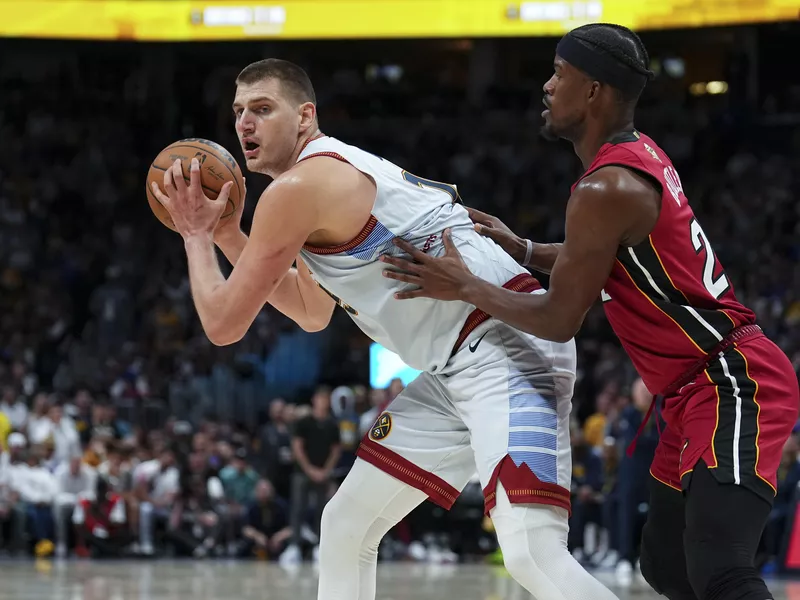 Nikola Jokic prepares to make a move on Jimmy Butler