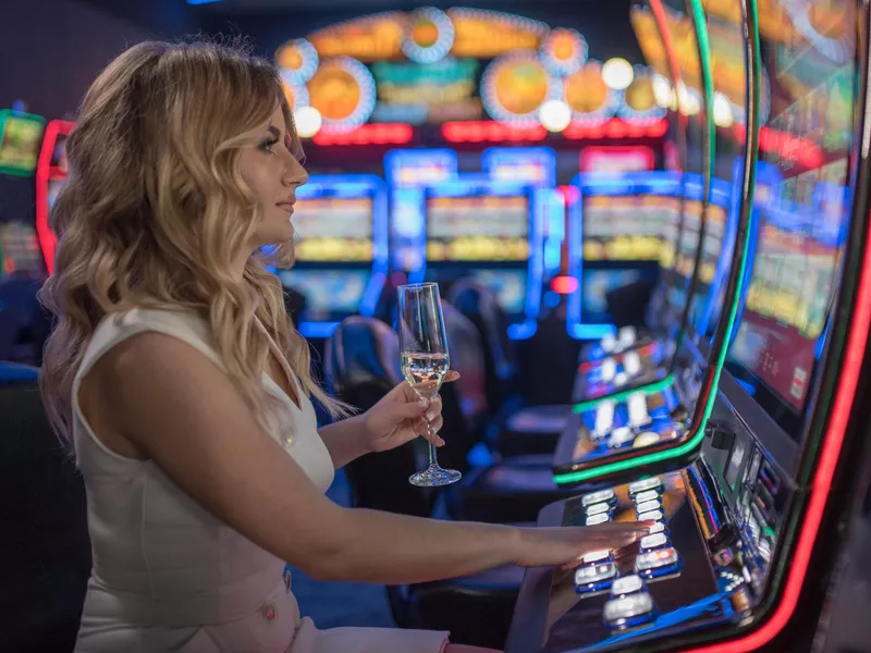 Woman playing slot machines in casino