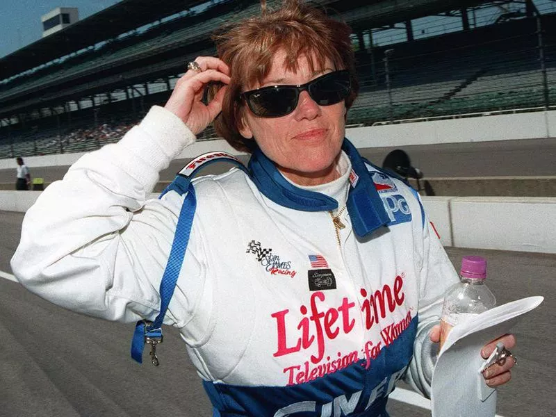 Lyn St. James walks through the pits