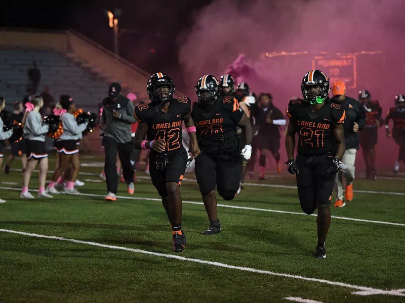 Lakeland High football players run on the field