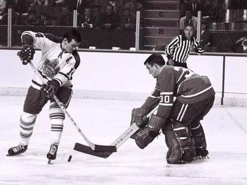 Dave Keon shoots puck