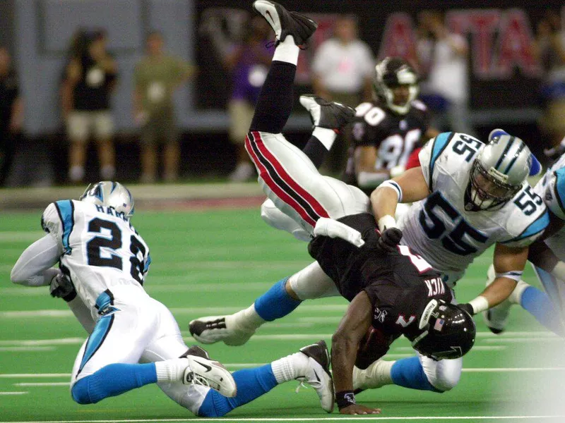 Panthers defenders Dan Morgan and Deveron Harper tackle Michael Vick