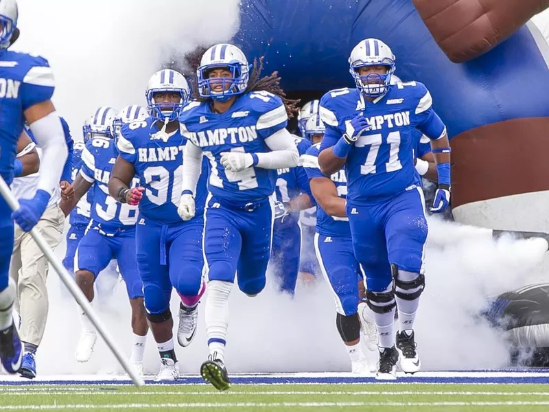 Hampton University football players running on the field