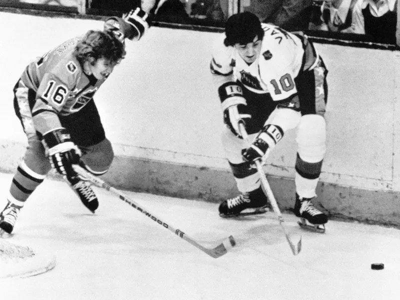 Carol Vadnais battles for possession of puck opponent Bobby Clarke