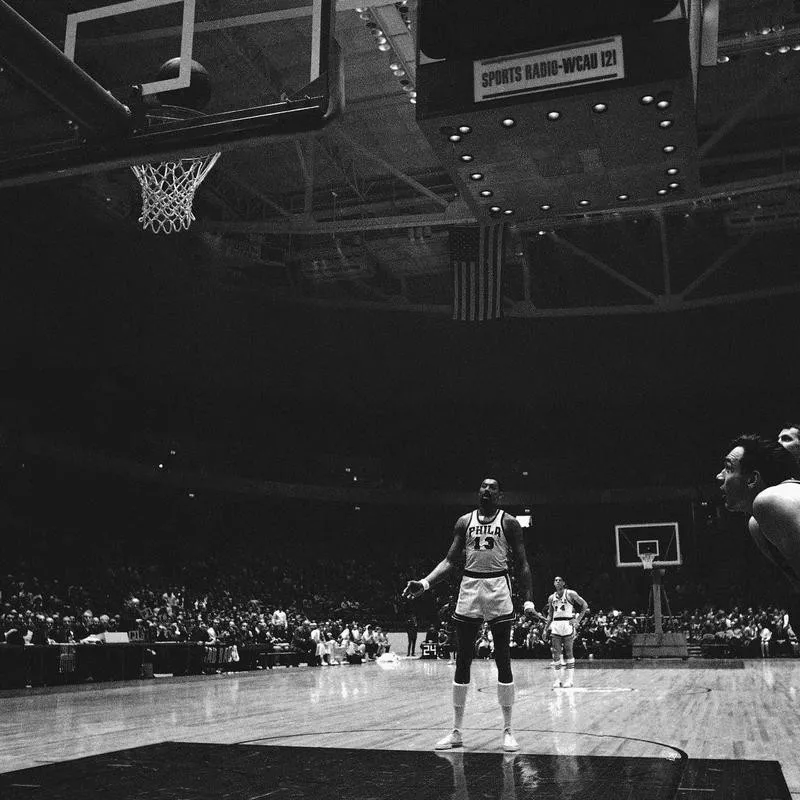 Wilt Chamberlain watches his basket