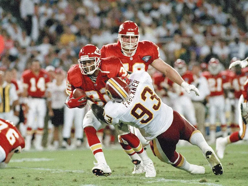 Washington Redskins defensive lineman Jeff Faulkner tackles Marcus Allen