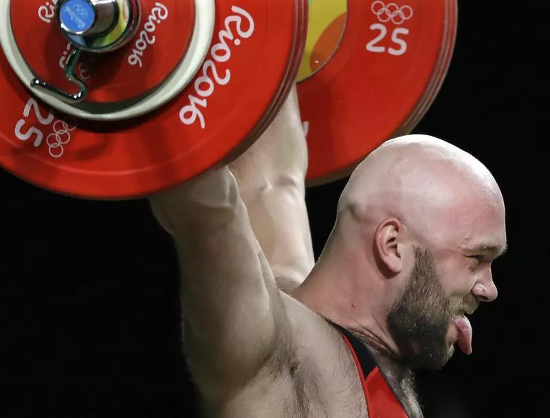 Ruslan Nurudinov sticks tongue out while lifting