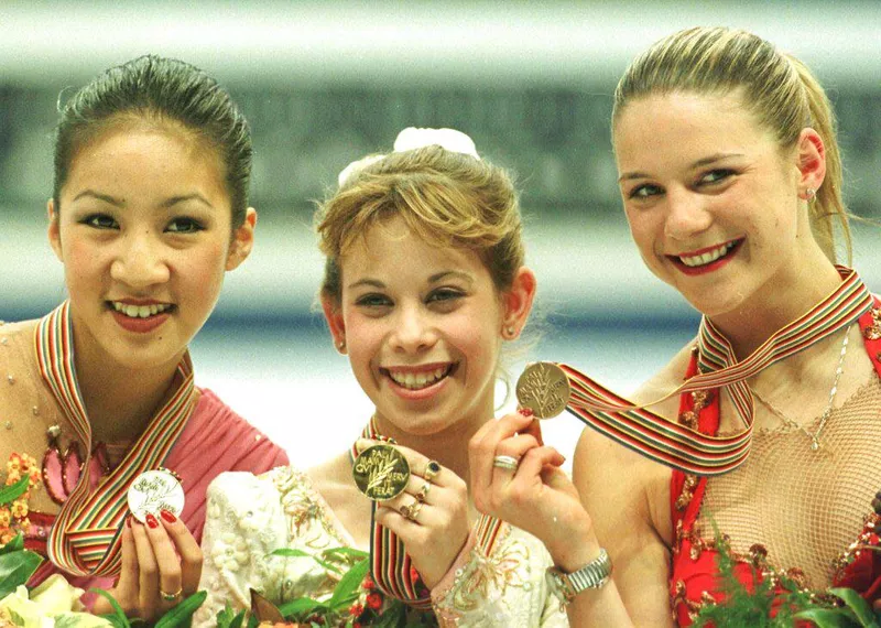 Tara Lipinski holding up her gold medal