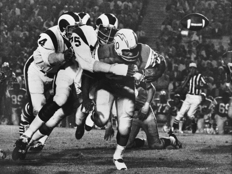 Los Angeles Rams defensive end Deacon Jones tackles San Diego Chargers running back Mike Garrett