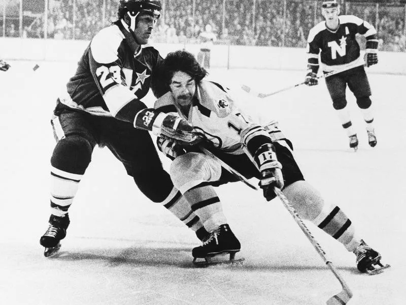 Derek Sanderson and Lou Nanne battle for puck