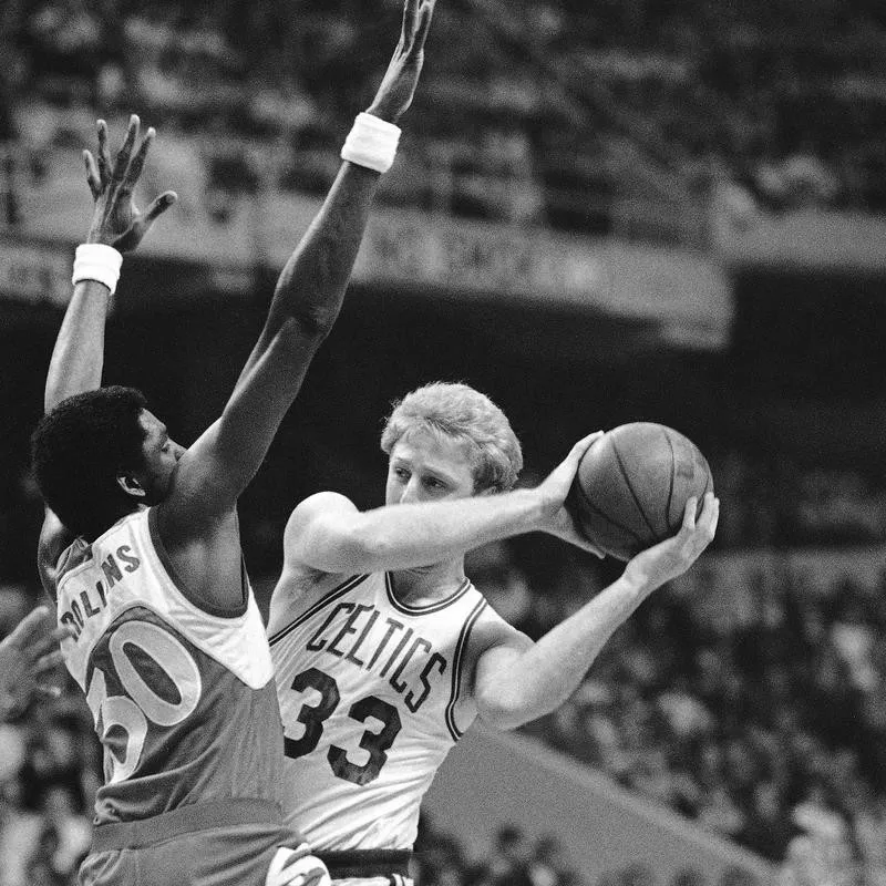 Tree Rollins defends Boston Celtics Larry Bird