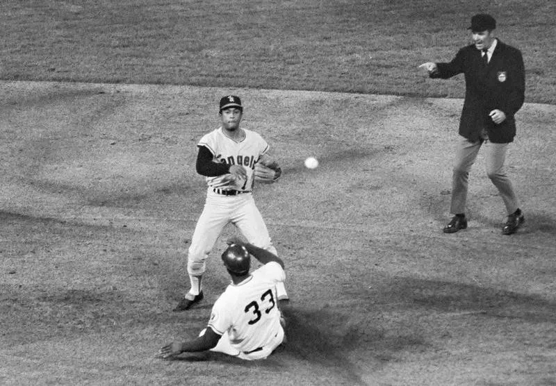 Sandy Alomar of the California Angels flips ball to first base