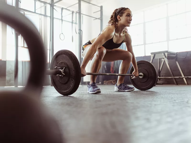 Woman lifting barbell at the gym