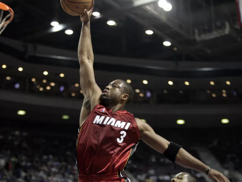 Dwyane Wade dunks in front of Detroit Pistons guard Rodney Stuckey