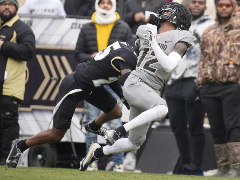 Colorado inside linebacker Marvin Ham II, left, runs into wide receiver Travis Hunter