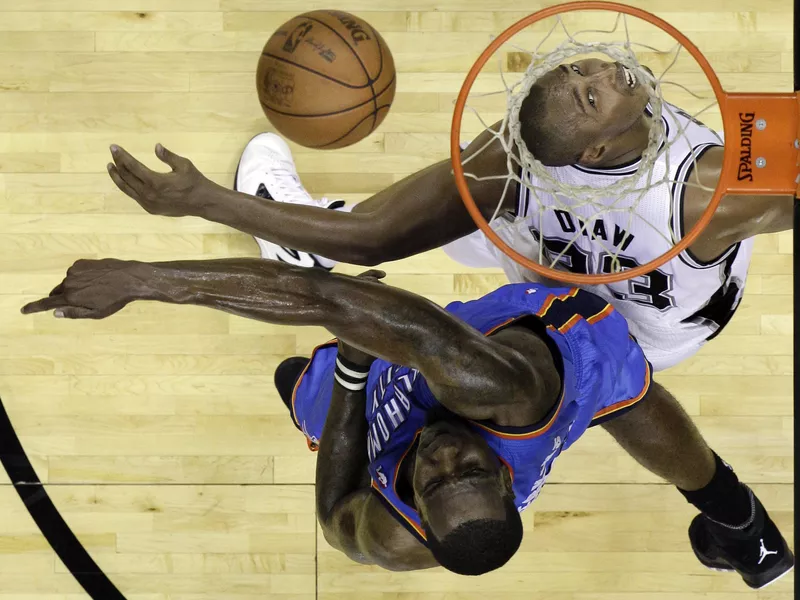 Oklahoma City Thunder center Kendrick Perkins and San Antonio Spurs power forward Boris Diaw go after loose ball