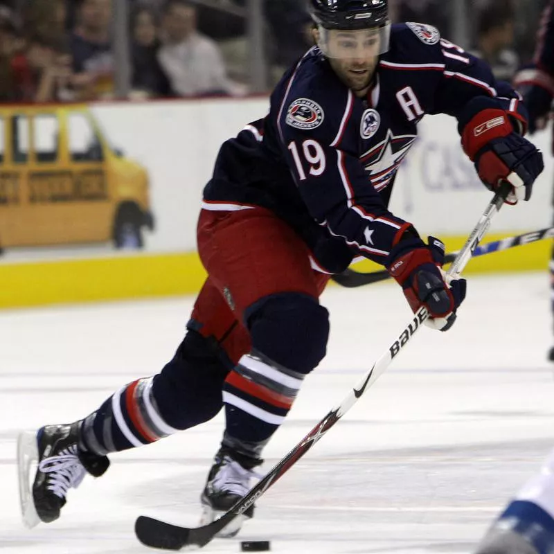 Michael Peca moves puck during game