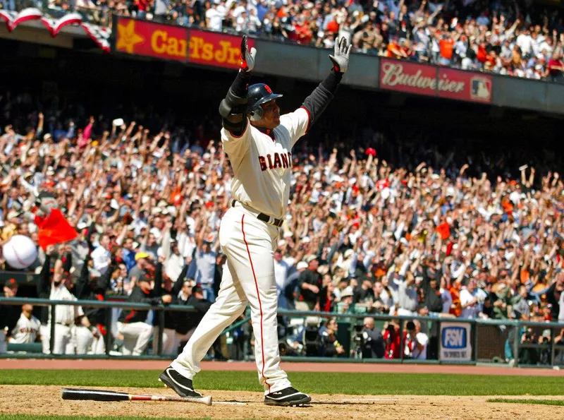 Barry Bonds raises arms after hitting a home run