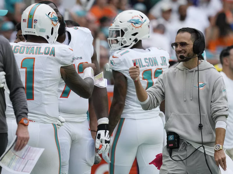 Miami Dolphins head coach Mike McDaniel fist bumps quarterback Tua Tagovailoa