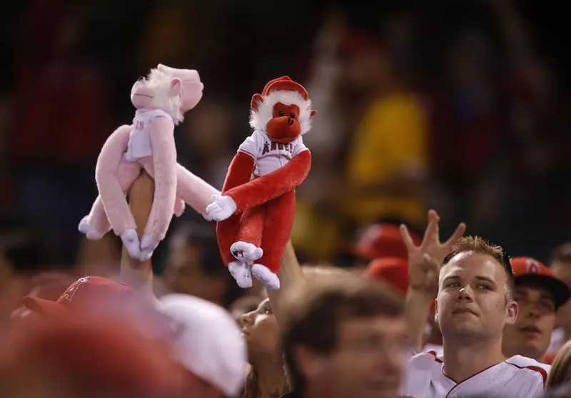 Fans hold up Rally Monkey dolls