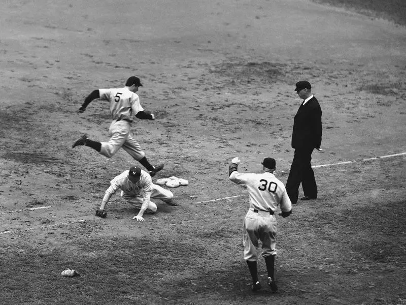 Joe DiMaggio leaps for first base