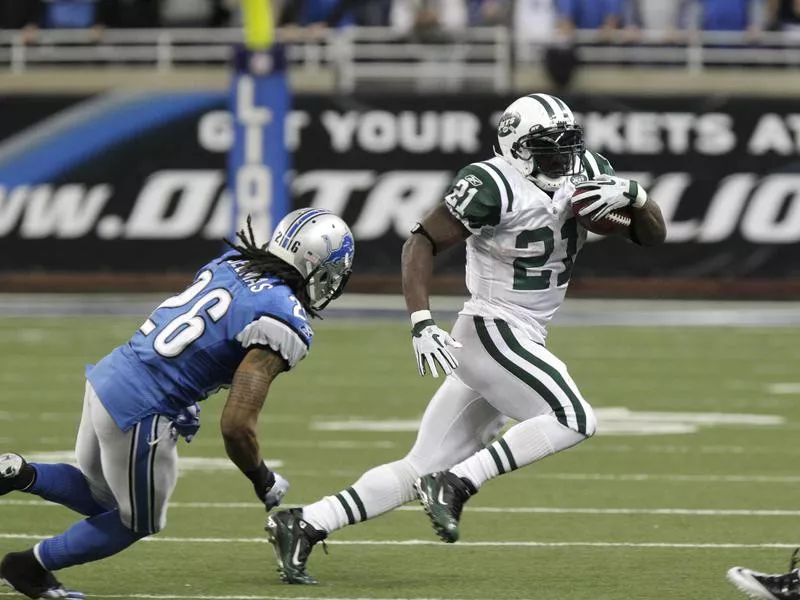 LaDainian Tomlinson runs past Detroit Lions safety Louis Delmas