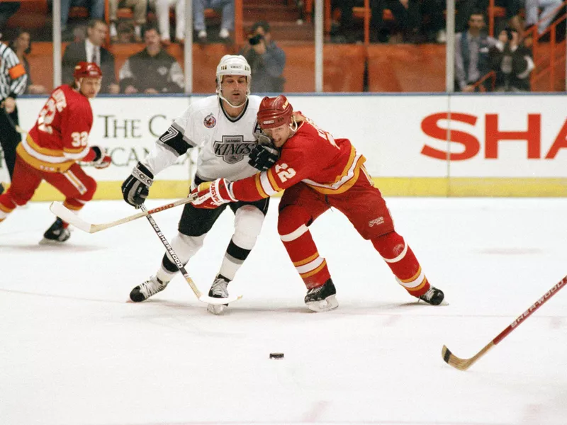 Paul Coffey skates against Paul Kruse