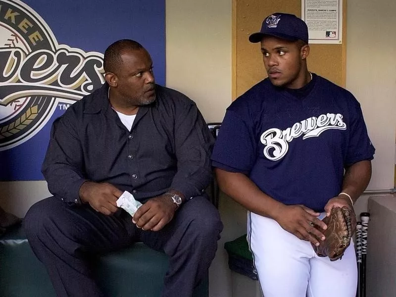 Prince Fielder talks to father Cecil Fielder in dugout in Milwaukee