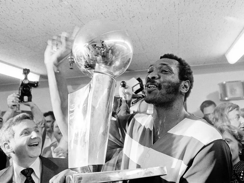 Washington Bullets player Elvin Hayes holds NBA Championship trophy