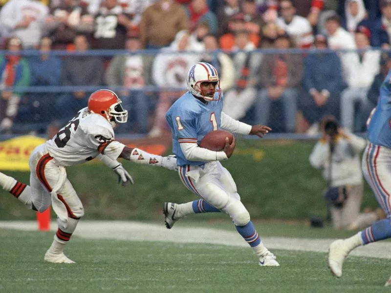 Houston Oilers quarterback Warren Moon scrambles away from Cleveland Browns