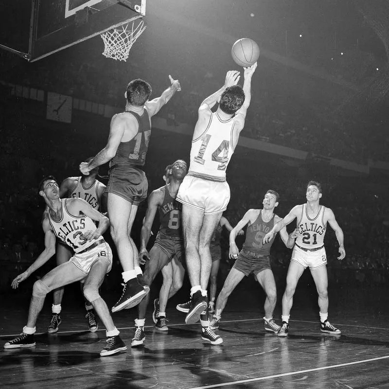 Boston Celtics Bob Cousy takes a rebound off