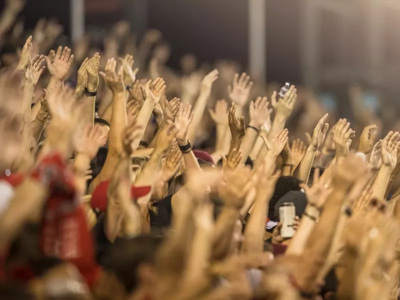 Passionate football fans cheer and raise hands