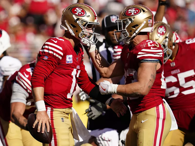 Brock Purdy and Christian McCaffrey celebrate