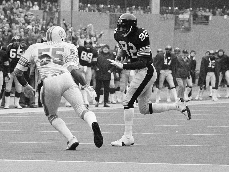 Steelers John Stallworth prepares to straight-arm Miami Dolphins Earnest Rhone