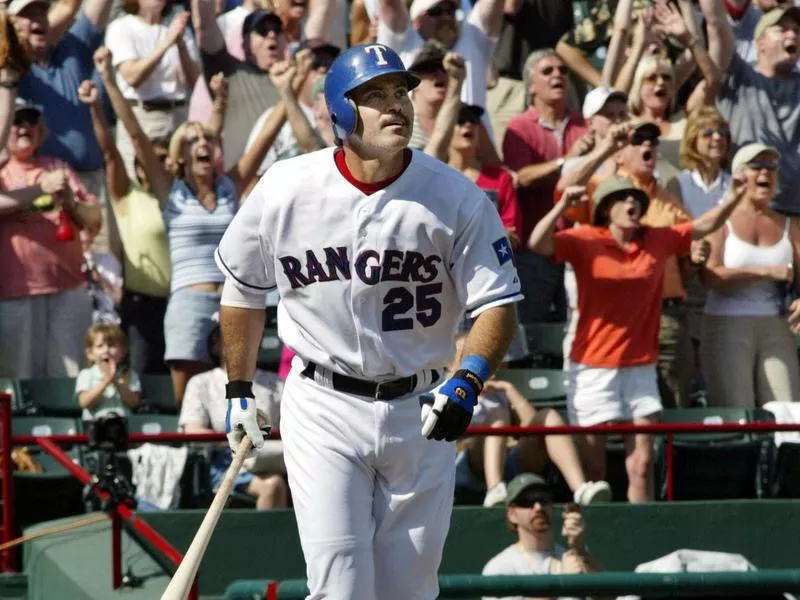 Rafael Palmeiro looks on at his home run