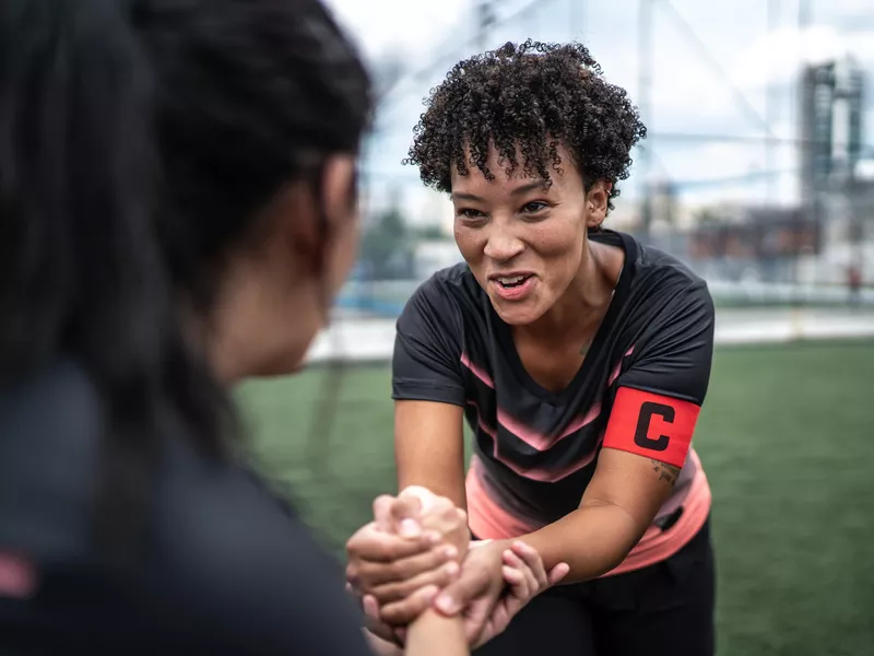 Woman soccer team captain encouraging teammate before game