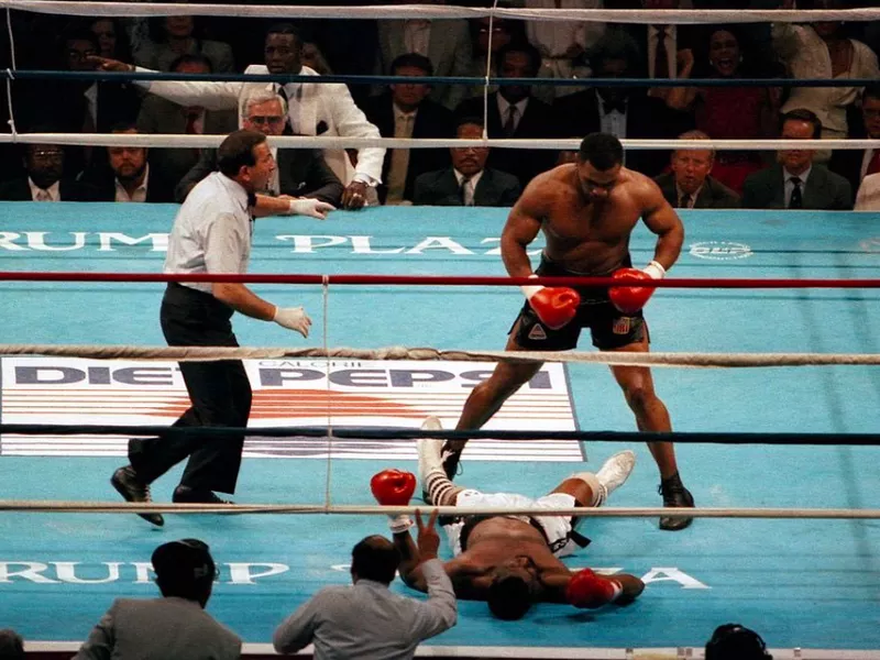 Mike Tyson stands over Michael Spinks