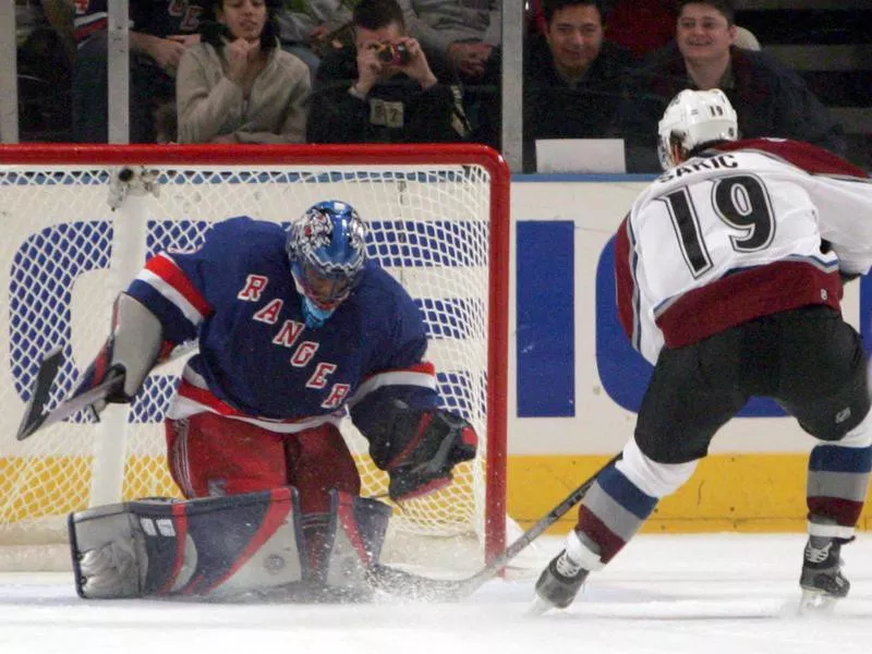 Joe Sakic scores a penalty goal against New York Rangers goalie Kevin Weekes