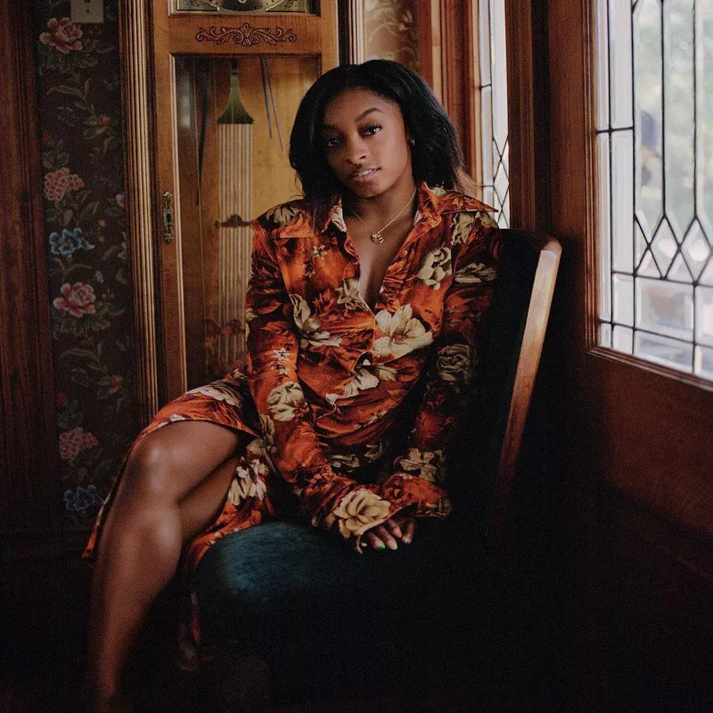 Simone Biles in a seated pose